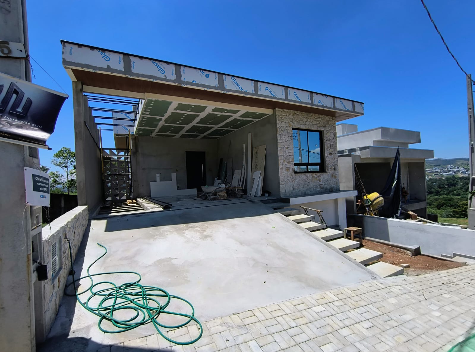 Fachada em construção com estrutura em concreto e pedra natural